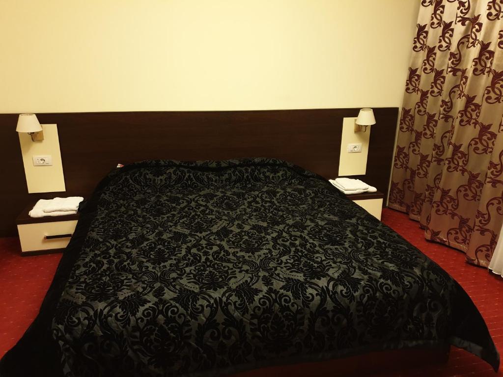 Camera dublă de la Casa Marly, cu pat matrimonial, noptiere și lumină caldă